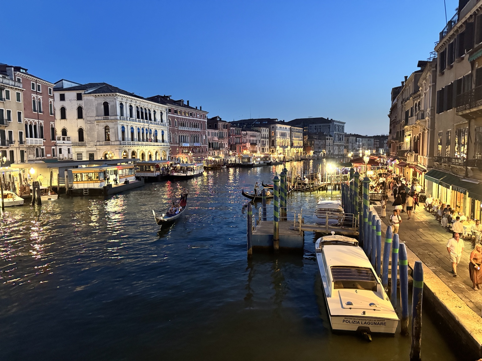 Večerní Grand Canal v Benátkách s gondolami a osvětleným nábřežím